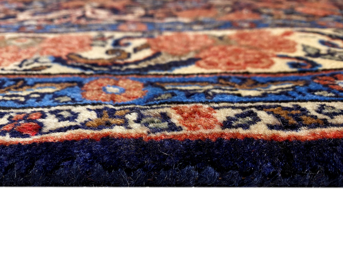 Plano aproximado da superfície do tapete, com detalhes ornamentais azuis e vermelhos e uma textura densa