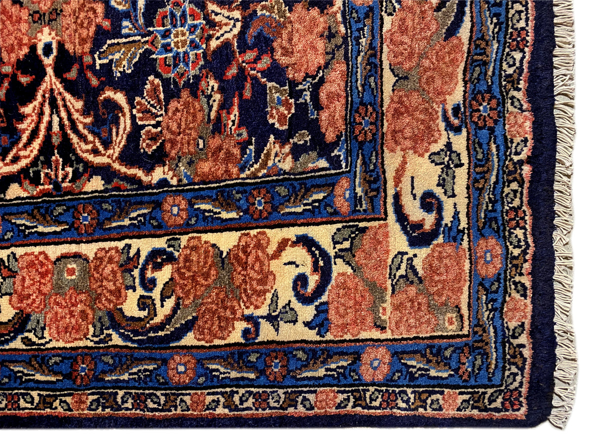 Canto de tapete com franjas e padrão ornamental azul e vermelho, acabamento da borda visível