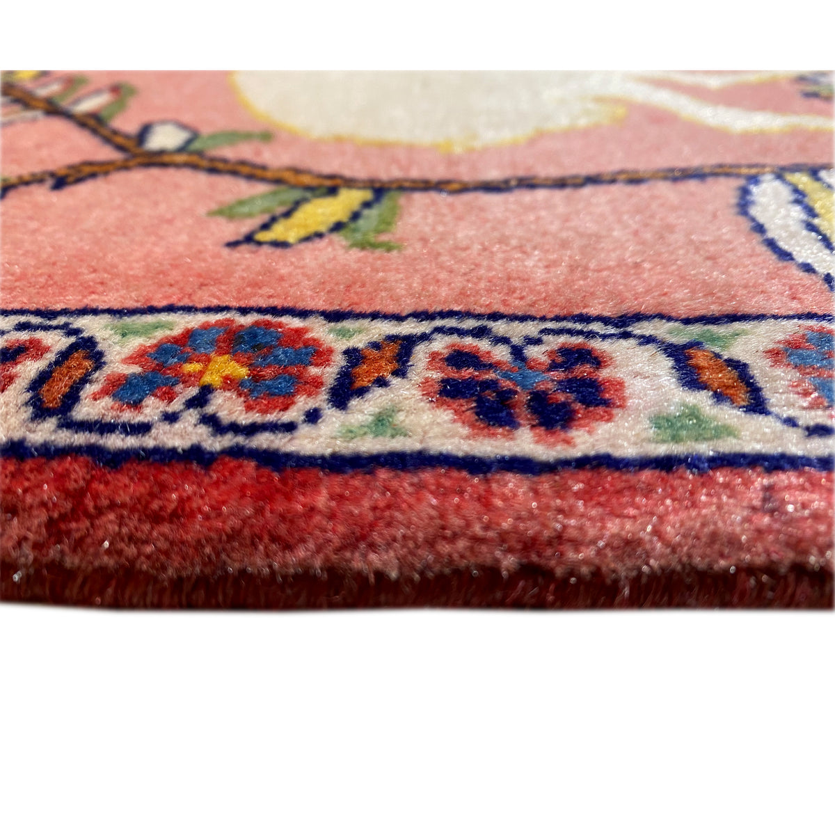 Orla de tapete em azul e vermelho com detalhes coloridos, rebordo plano e pelo denso