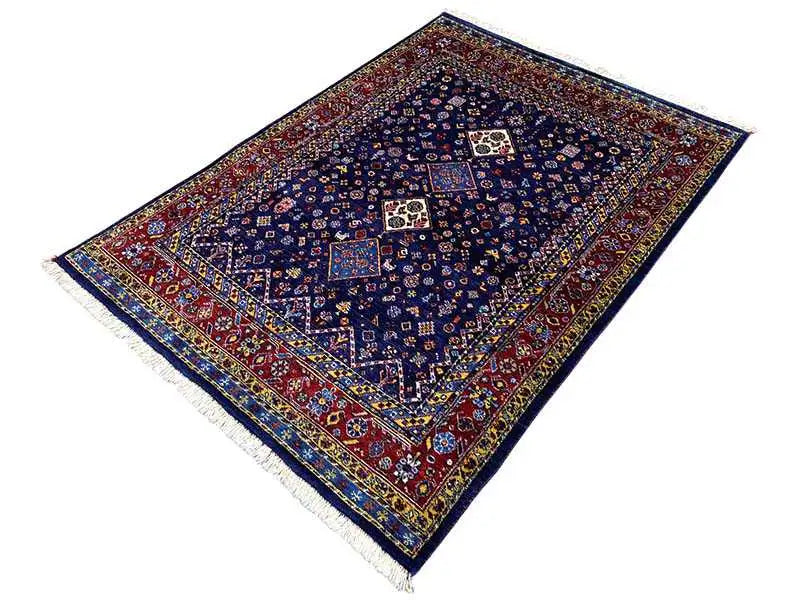 Tapete oriental com fundo azul, bordas vermelhas e padrão de medalhão simétrico