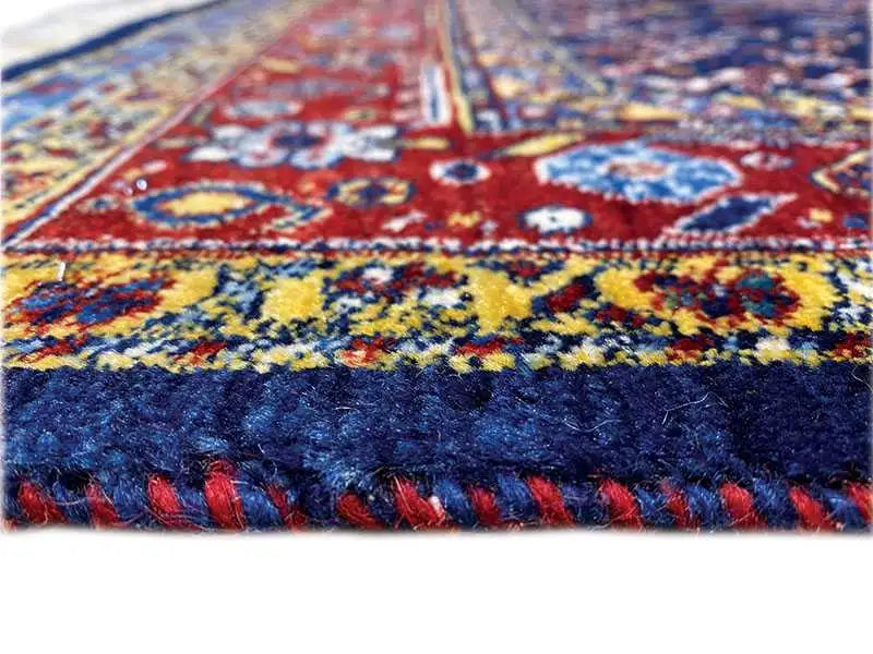 Orla de tapete com padrão colorido e franjas em azul e vermelho