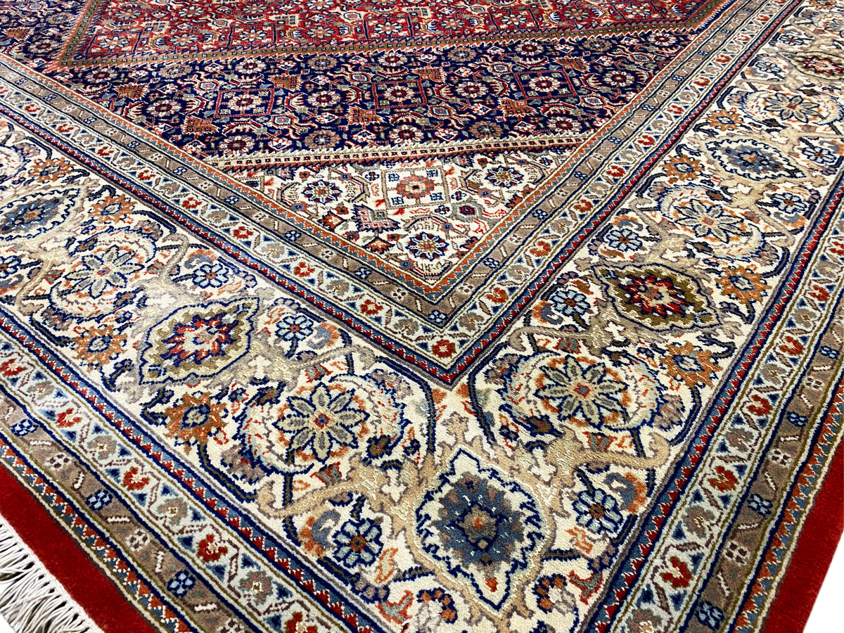 Vista de detalhe: centro azul com motivos florais, ornamentos circundantes e detalhes vermelhos