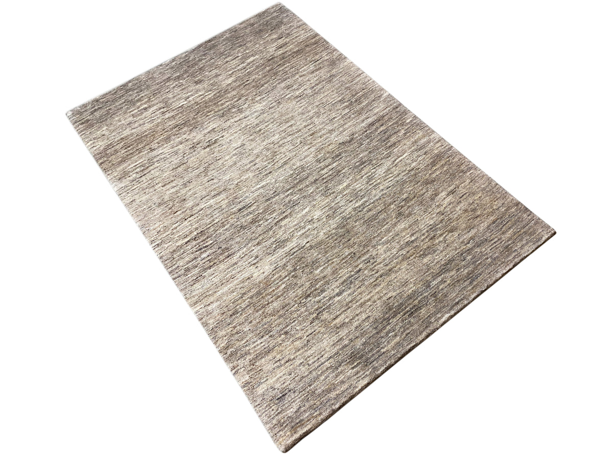 Tapete Gabbeh retangular, ligeiramente inclinado, em mescla bege-acinzentada com textura fina