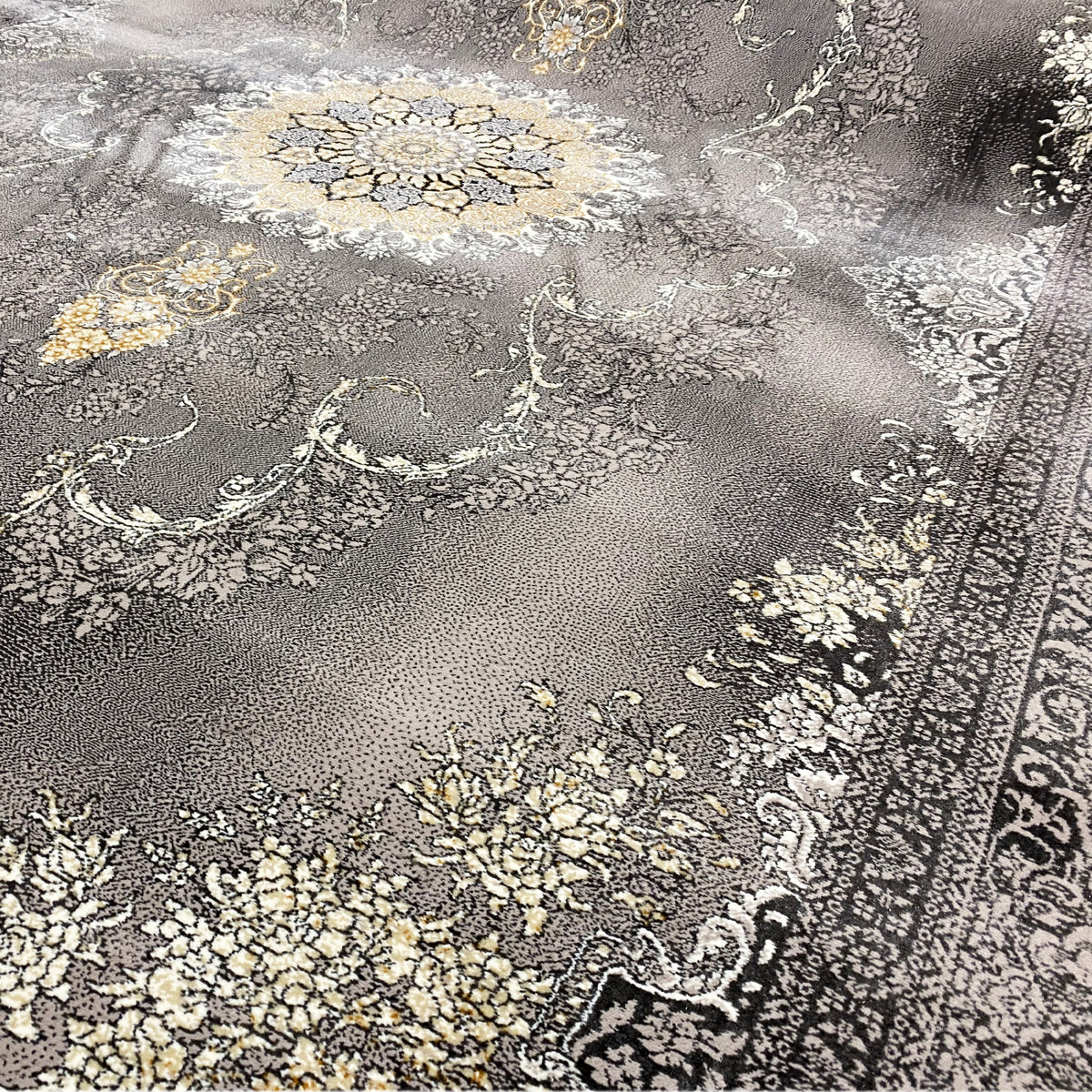 Vista detalhada de um tapete Kashan: pelo cinzento com ornamentos florais em dourado e bege