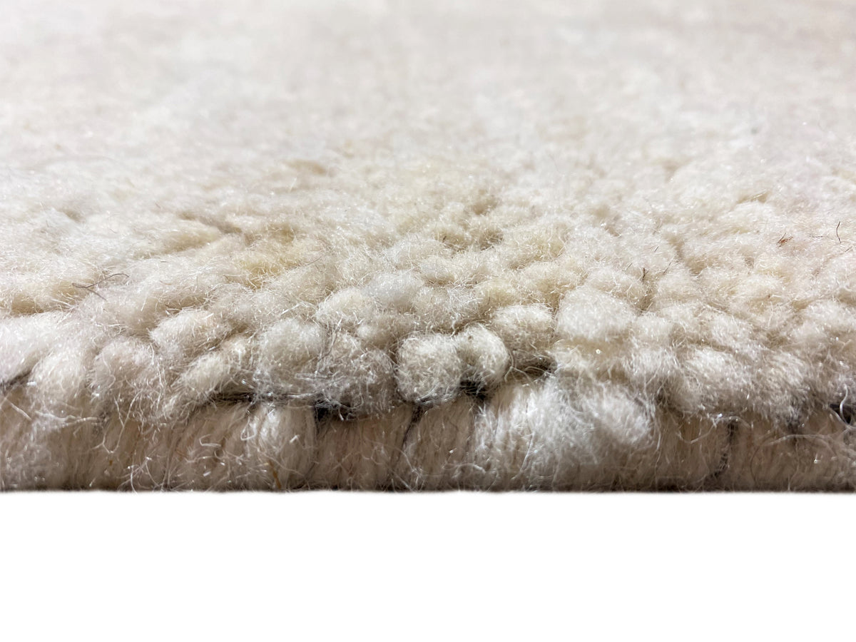 Vista lateral: pelo denso de cor creme com bordo inferior azul