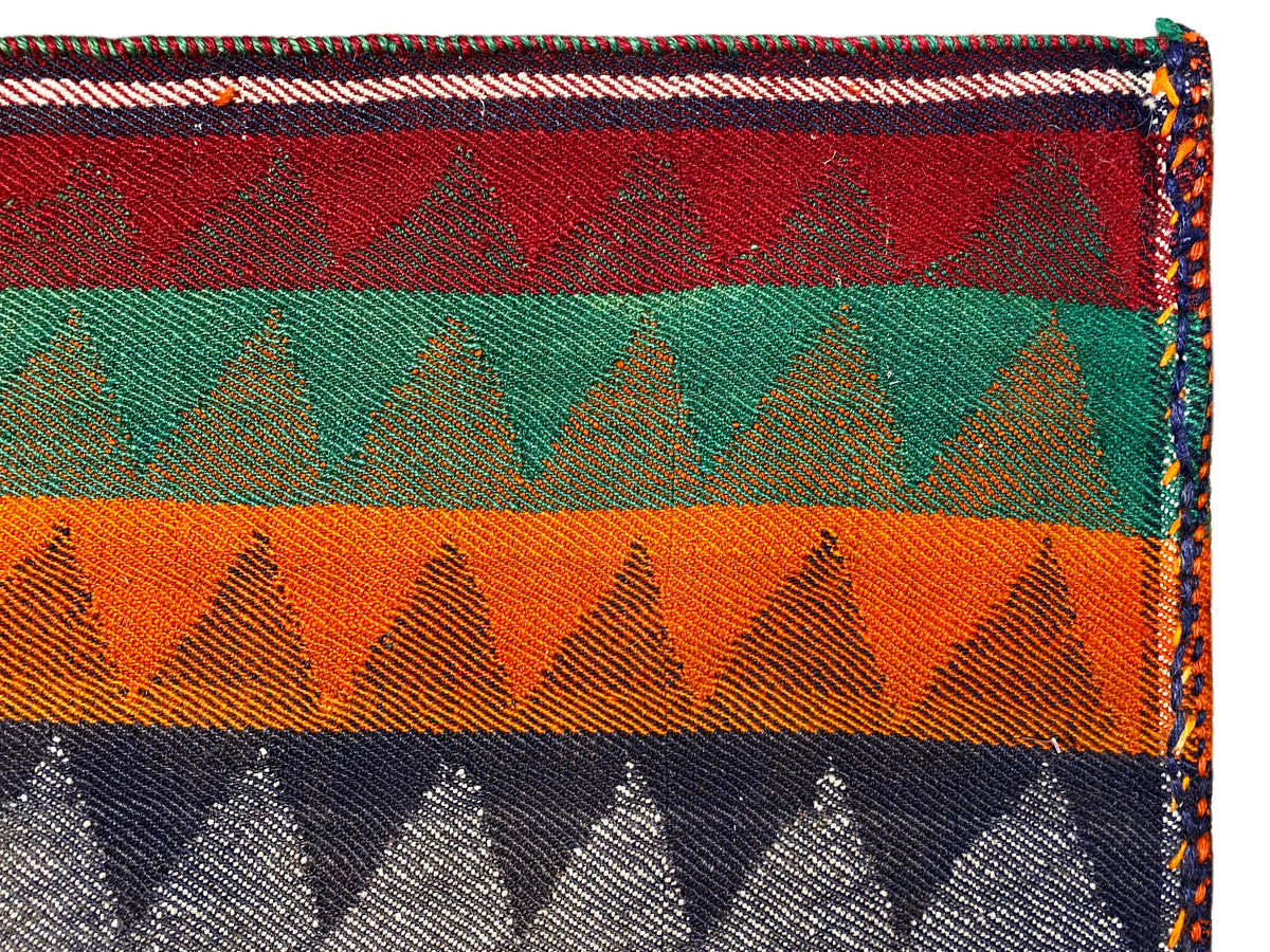 Detalhe do tapete de corredor Jajim: riscas multicoloridas, padrão em ziguezague, borda debruada