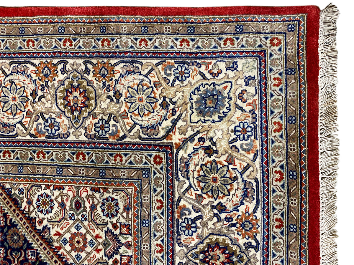 Canto do tapete com franjas: área de padrão claro, contorno vermelho e faixas com padrão azul