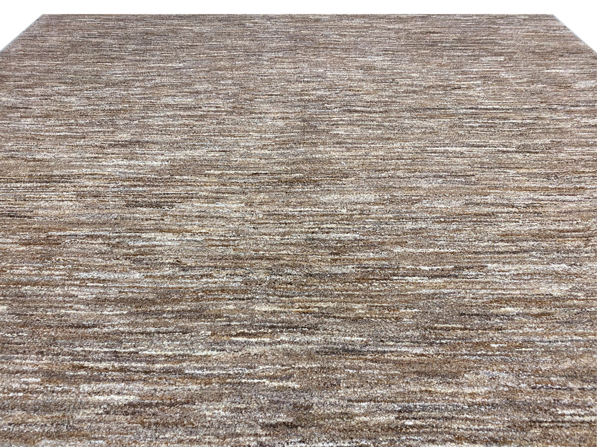 Grande plano de um tapete Gabbeh: delicado jogo de linhas, pelo curto castanho-bege