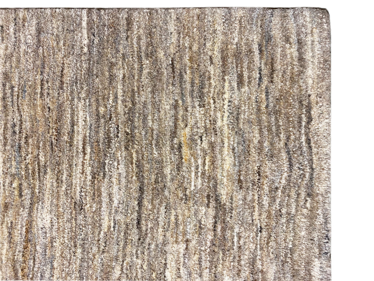 Tapete Gabbeh, em grande plano: textura às riscas mesclada em bege e cinzento e pelo curto
