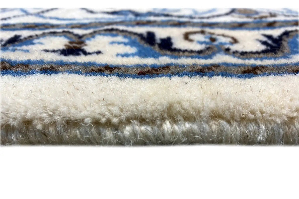 Franjas de tapete na borda, orla azul e branca e padrão floral, lã texturizada