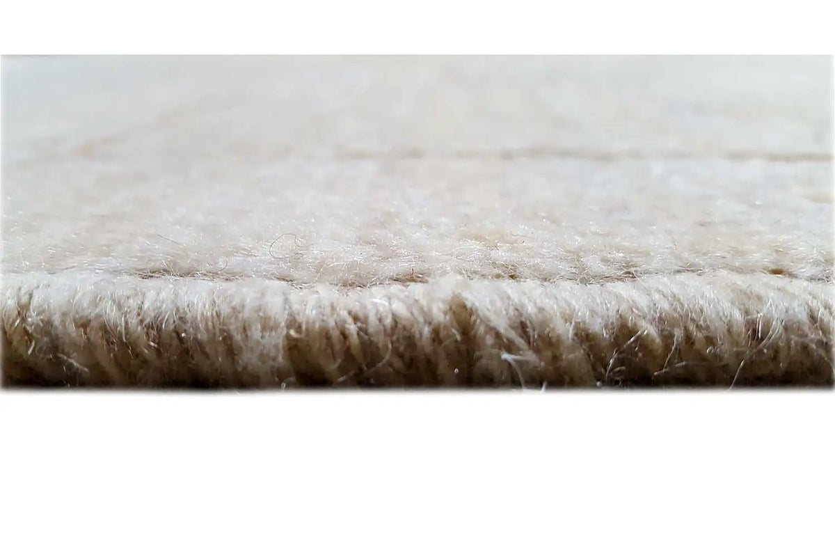 Grande plano de um tapete Gabbeh: pelo bege com franjas curtas na extremidade