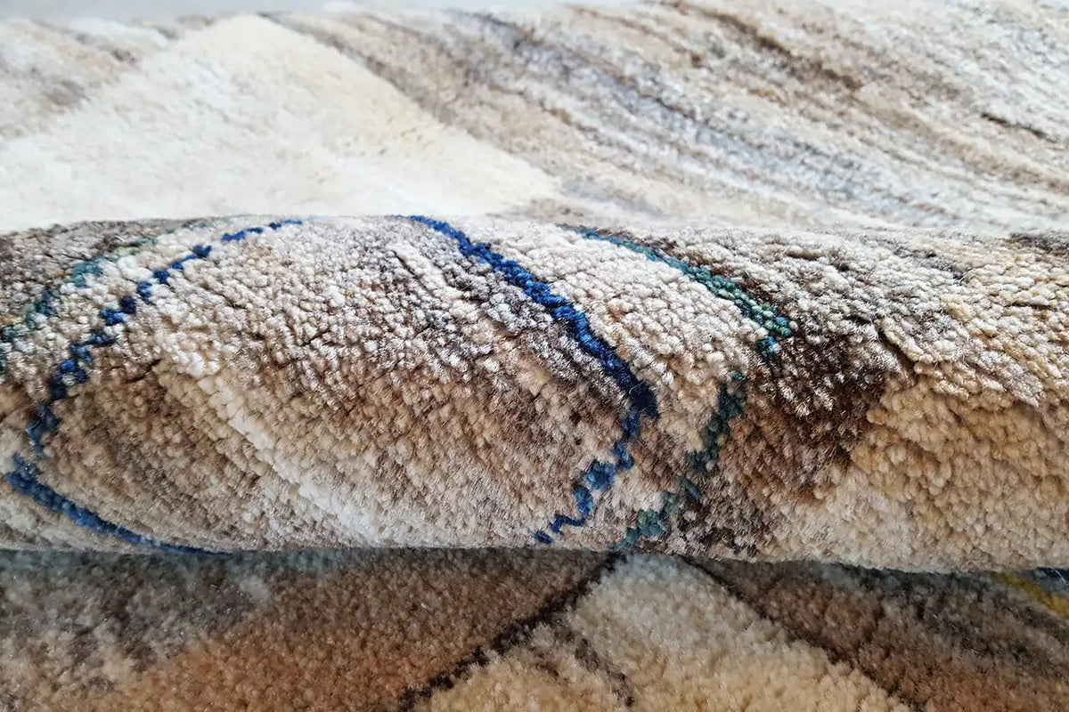 Grande plano de um tapete Gabbeh: pelo com faixa decorativa azul sobre fundo bege