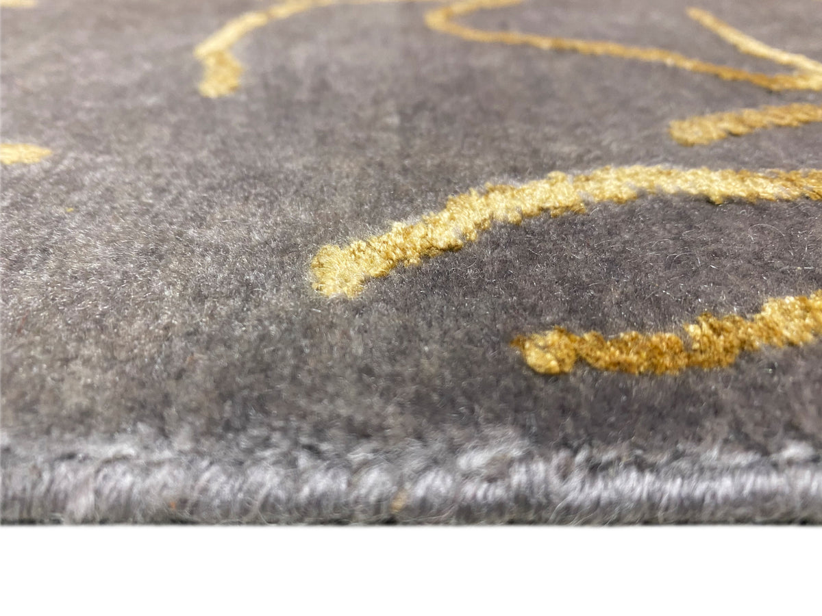Designer-Teppich Nahansicht: grauer Flor mit gelben Musterlinien und gefranster Kante