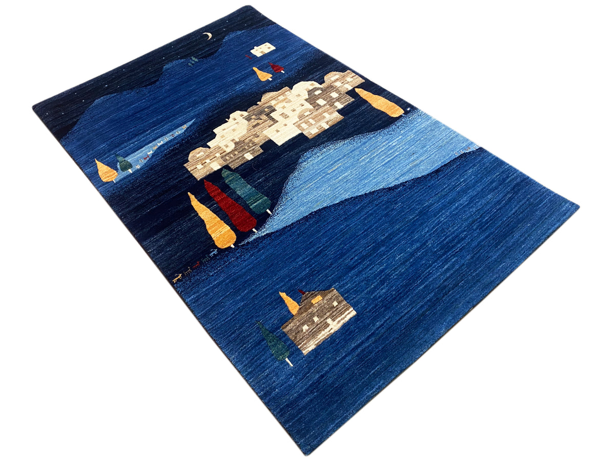 Blauer Teppich mit abstrakten beige und farbigen Motiven, diagonale Ansicht