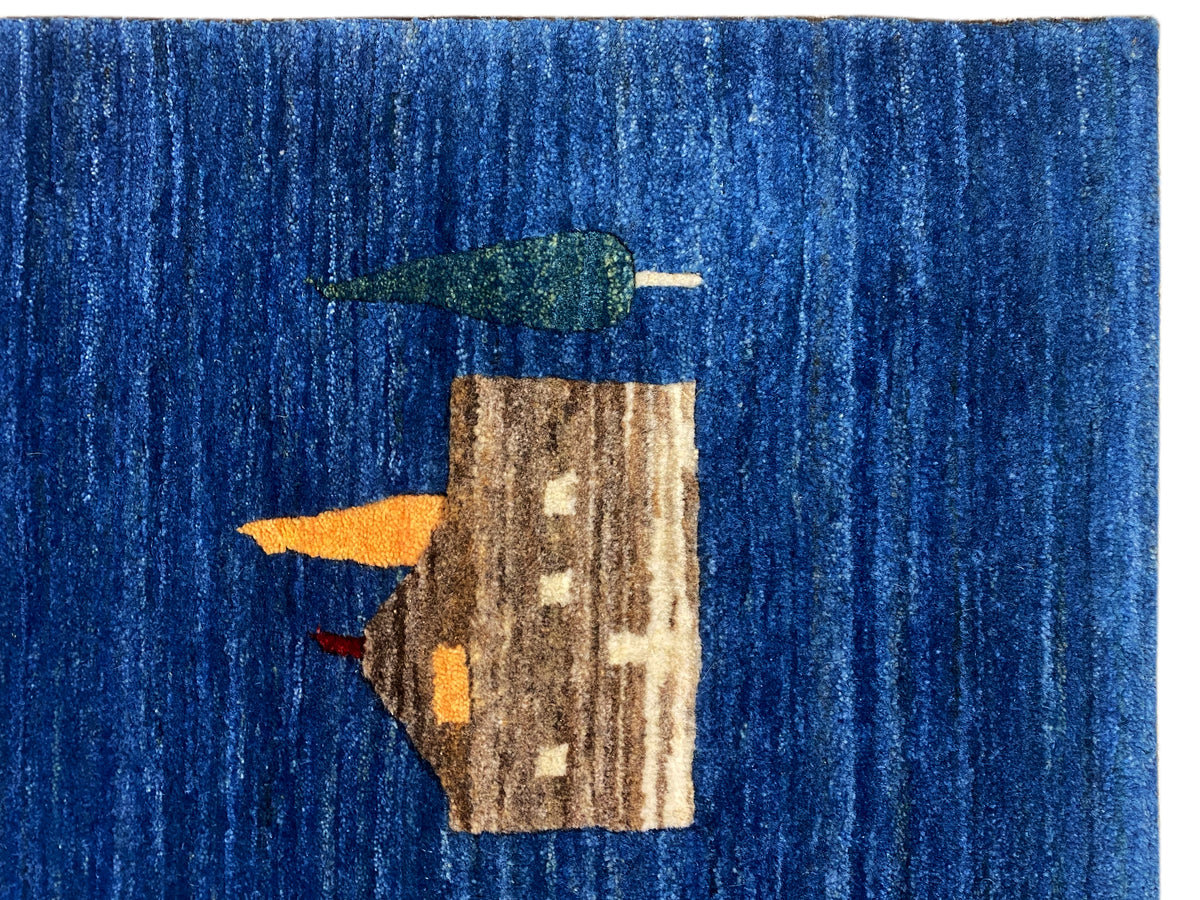 Blauer Teppich im Detail: beige Blockmotive mit grünen und gelben Farbakzenten