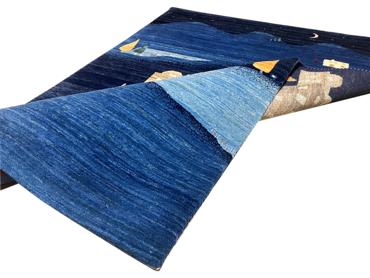 Blauer Teppich mit Reliefabschnitten in beige sowie orange und gelben Farbpunkten
