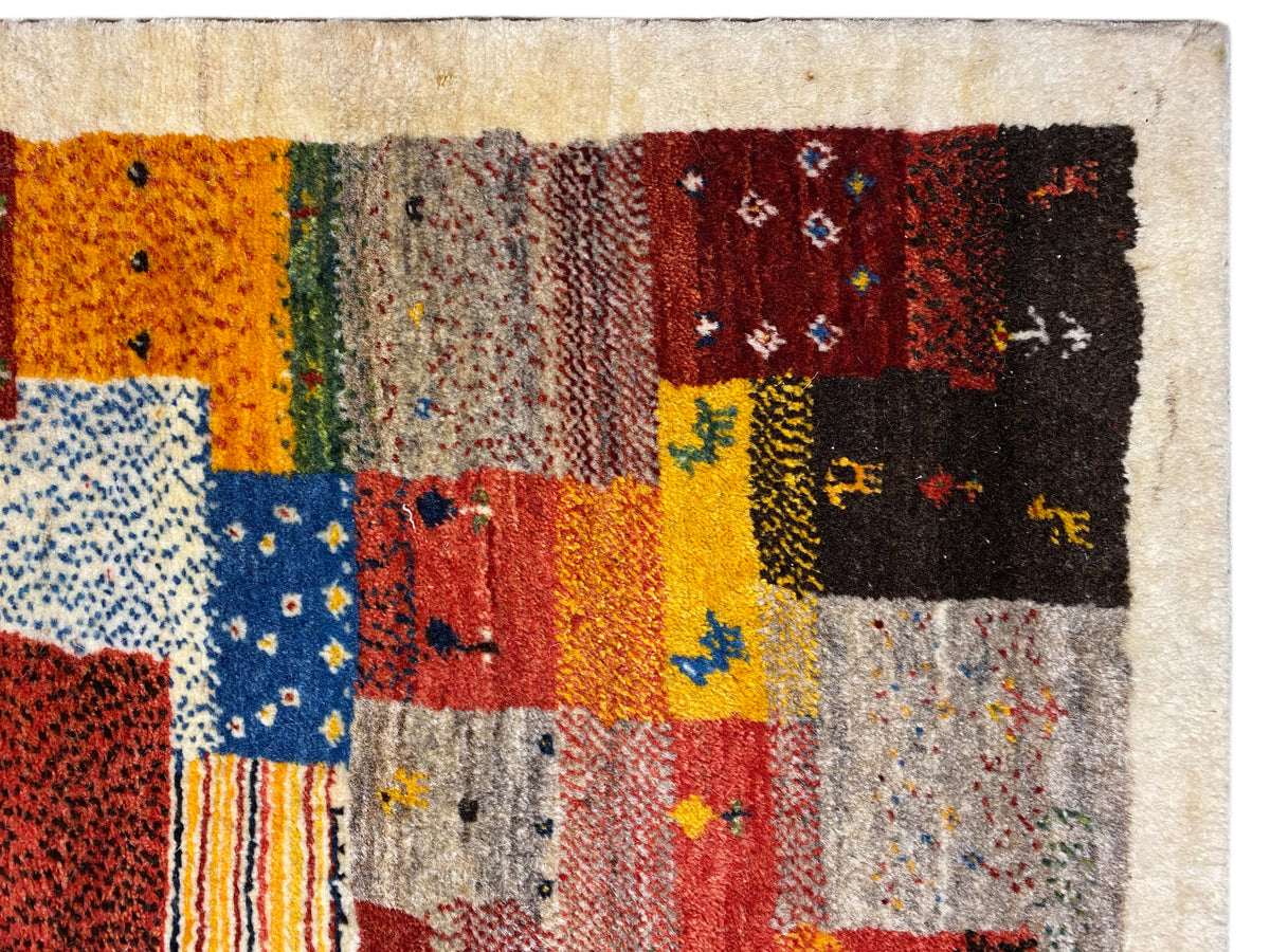 Tapete Gabbeh Luri 145x105 cm em grande plano: campos de patchwork cor de laranja, amarelos e azuis