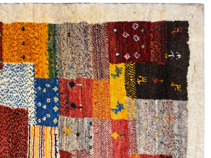 Tapete Gabbeh Luri 145x105 cm em grande plano: campos de patchwork cor de laranja, amarelos e azuis
