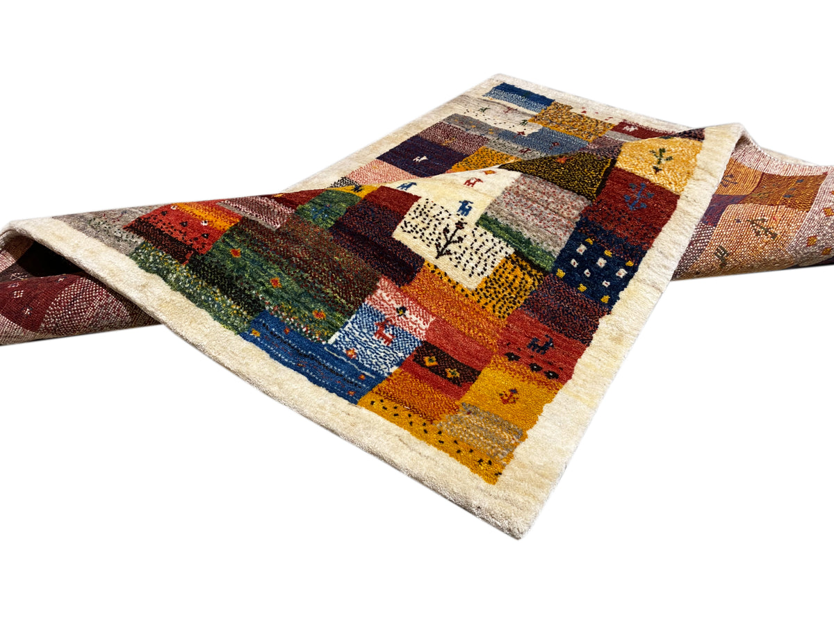 Tapete Gabbeh Luri 145x105 cm, drapeado na diagonal, com blocos de patchwork em vermelho, azul e amarelo