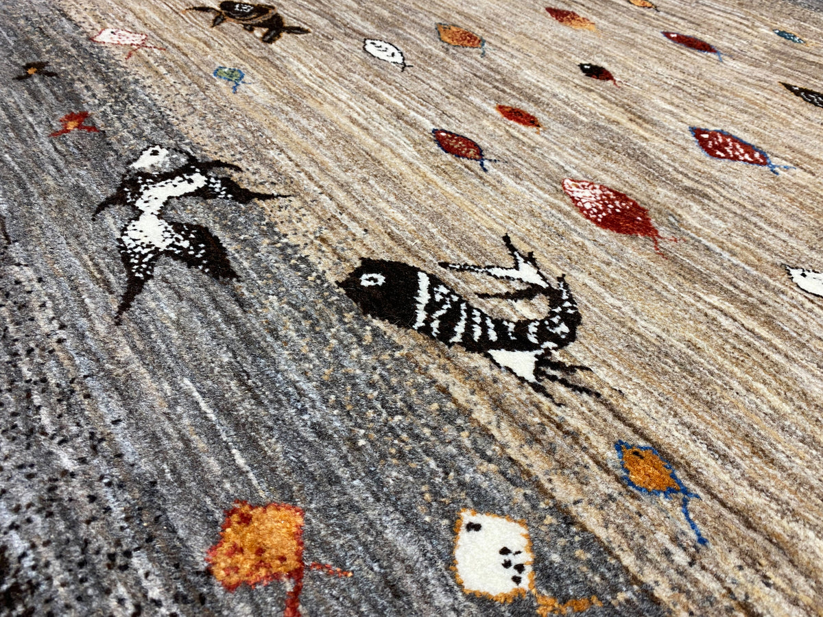 Detailansicht mit eingewebten Tiermotiven und bunten Punkten auf hellem Untergrund