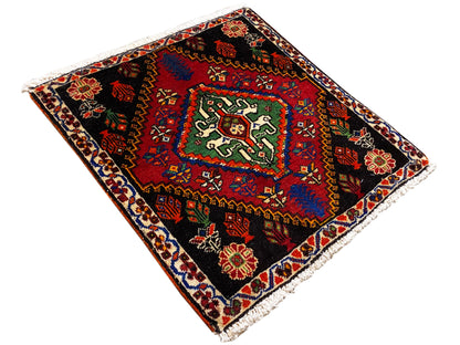 Tapete Poshti 56x56 cm, colocado na diagonal, com ornamentos geométricos em vermelho, verde e azul