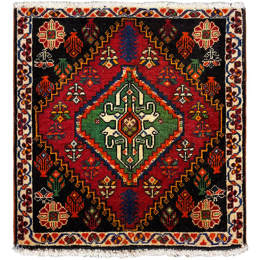 Tapete Poshti quadrado: tapete tecido preto com padrão decorativo vermelho, verde e azul