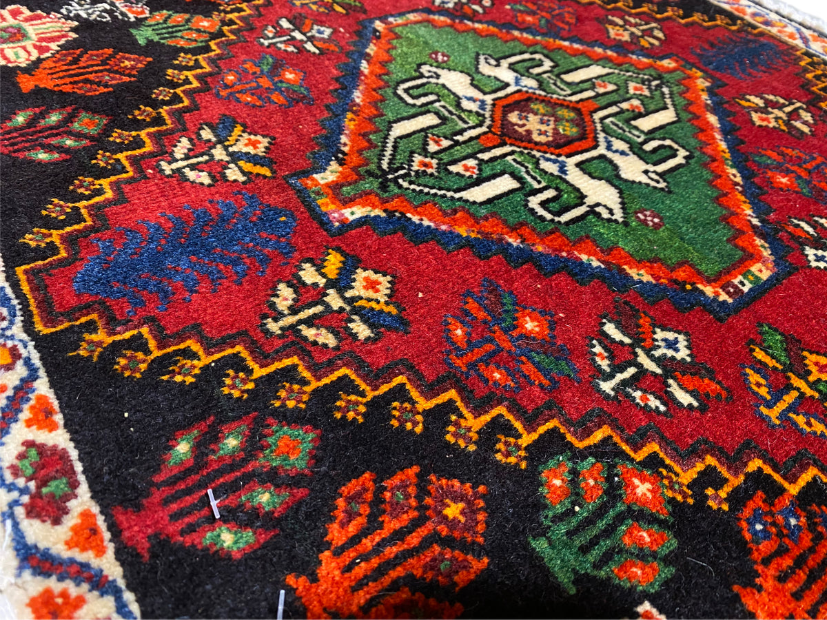 Tapete Poshti, vista detalhada de um canto: ornamentos geométricos multicoloridos sobre fundo preto