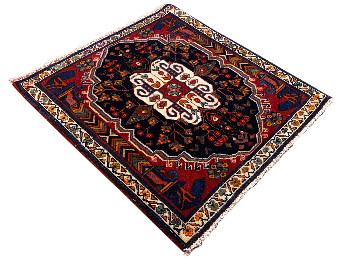 Tapete Poshti com padrão de losangos, fundo escuro e ornamento central branco