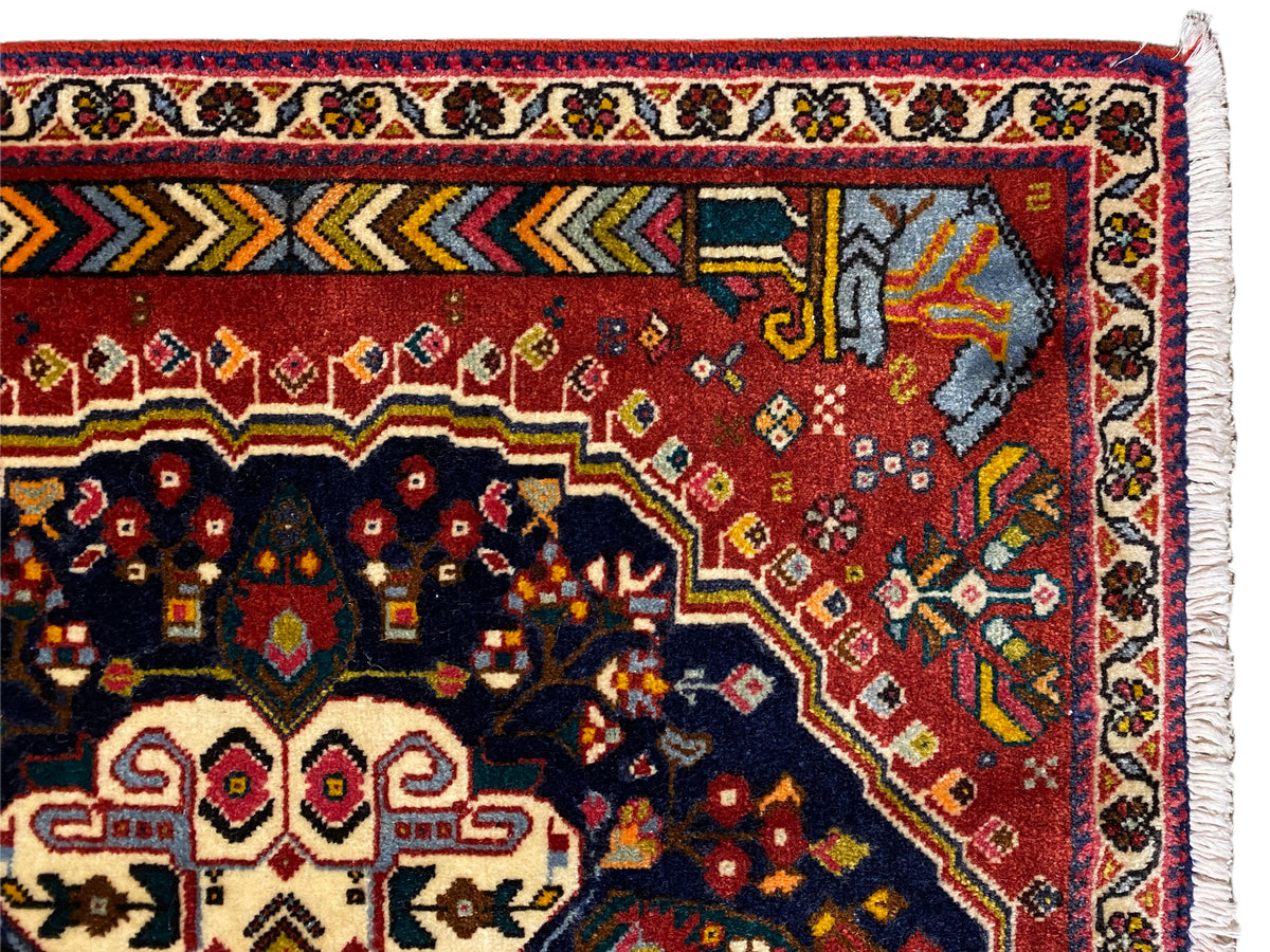 Detalhe da bordadura do tapete Poshti com ornamentos vermelhos, azuis e amarelos
