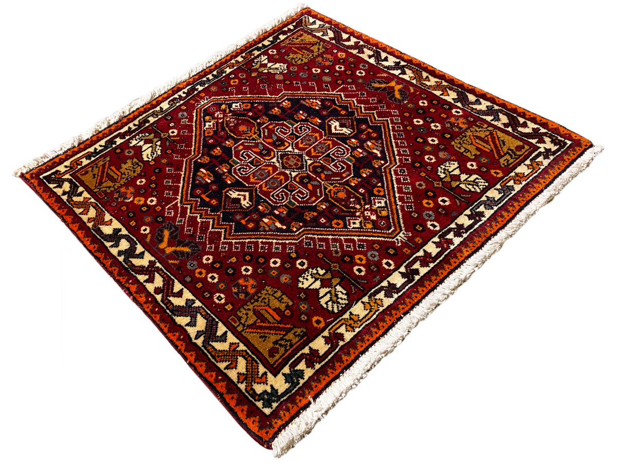 Tapete Poshti 60x60 cm, padrão de cercadura vermelho com medalhão central escuro e franjas