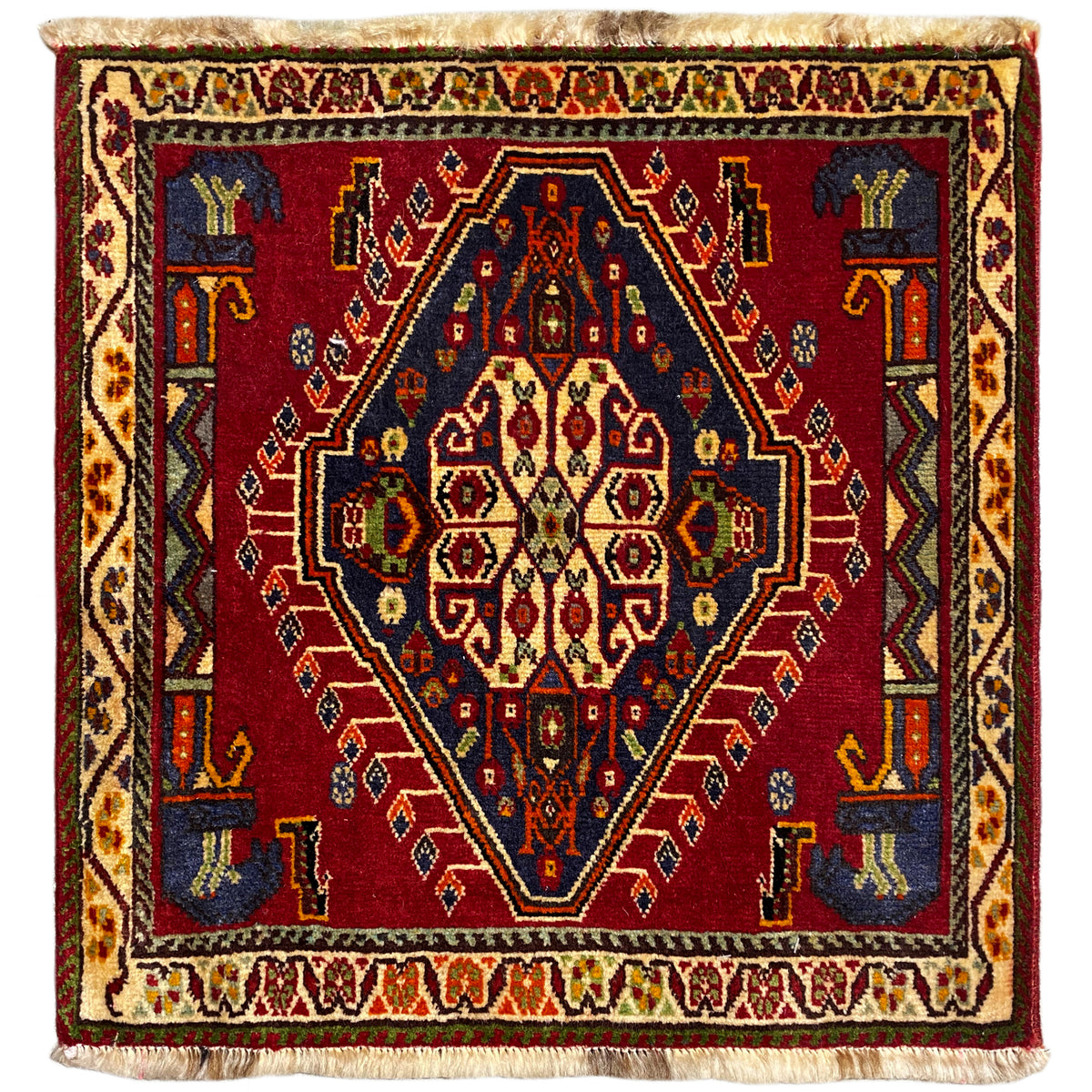 Tapete Poshti (59×61 cm) com padrão vermelho, bordaduras multicoloridas e franjas