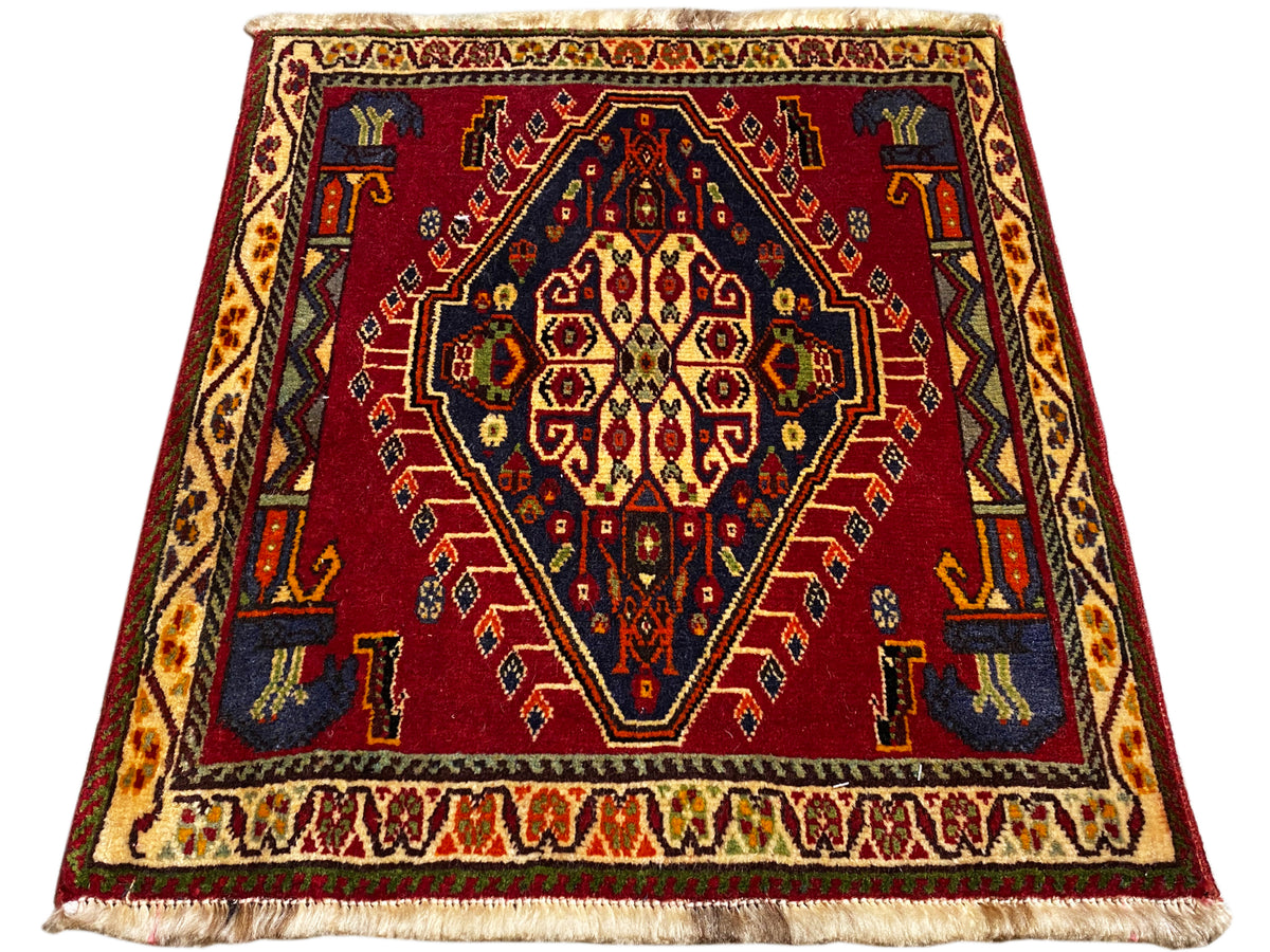 Tapete Poshti (59×61 cm) vermelho com medalhão central, borda decorativa e franjas