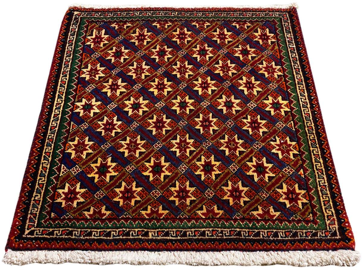 Tapete Poshti 62x52 cm, vista diagonal: padrões vermelhos, azuis e verdes com franjas.