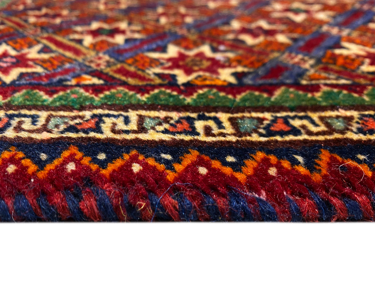 Tapete Poshti 62x52 cm em grande plano: riscas coloridas e franjas de pelo alto.