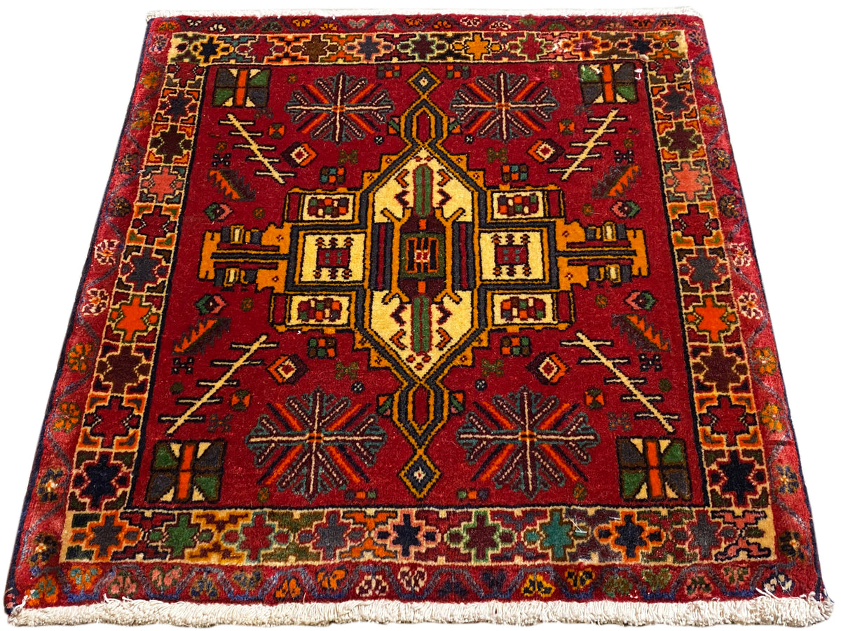 Tapete Poshti vermelho com padrão central simétrico e bordadura multicolorida