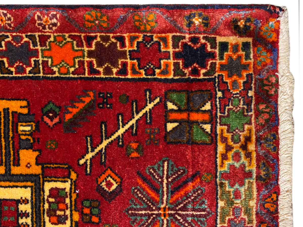 Grande plano: tapete Poshti com fundo vermelho, ornamentos coloridos e cercadura multicolorida