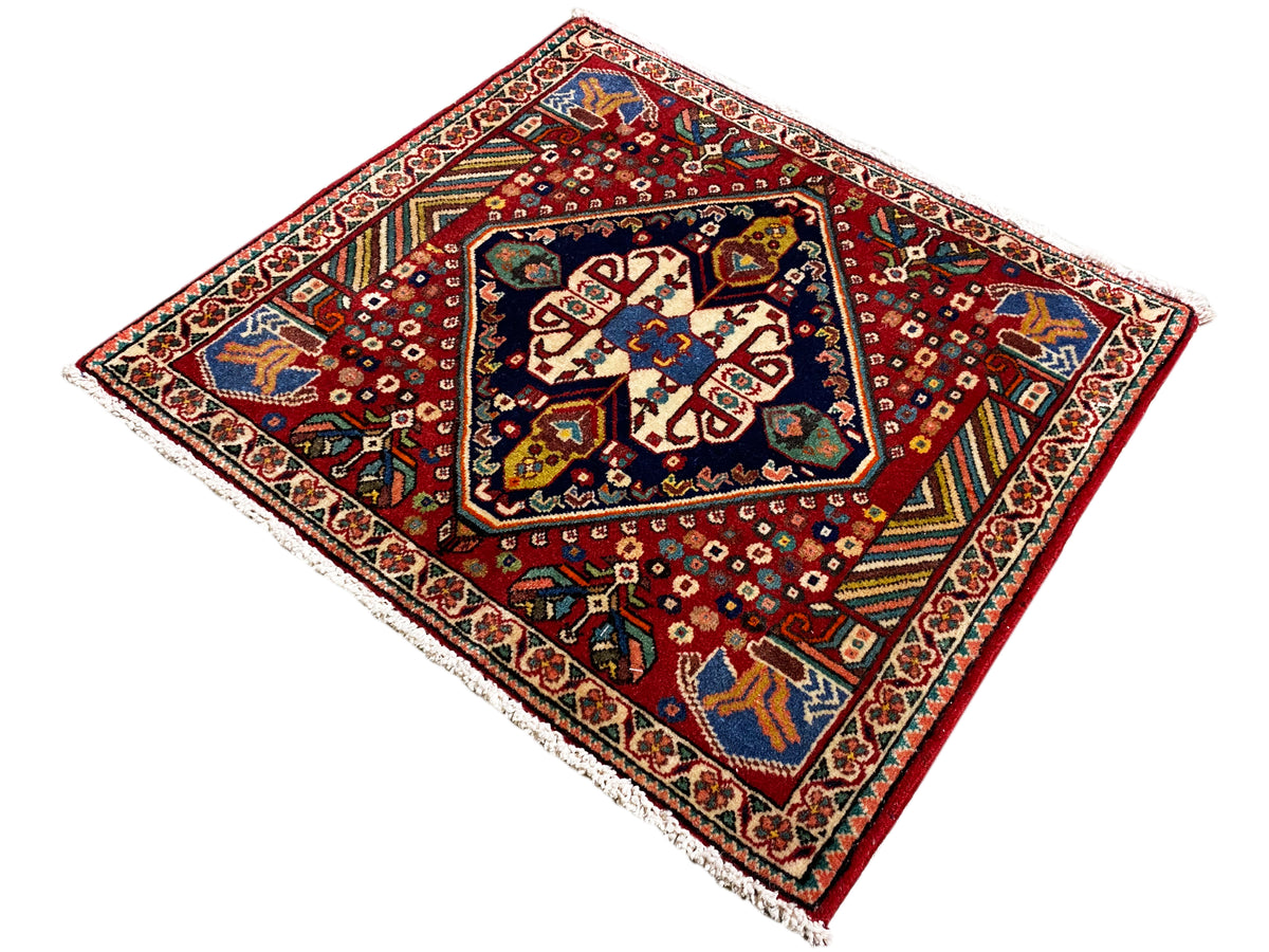 Tapete 66x62 cm, fundo vermelho com ornamentos azul-esverdeados e friso de borda branco