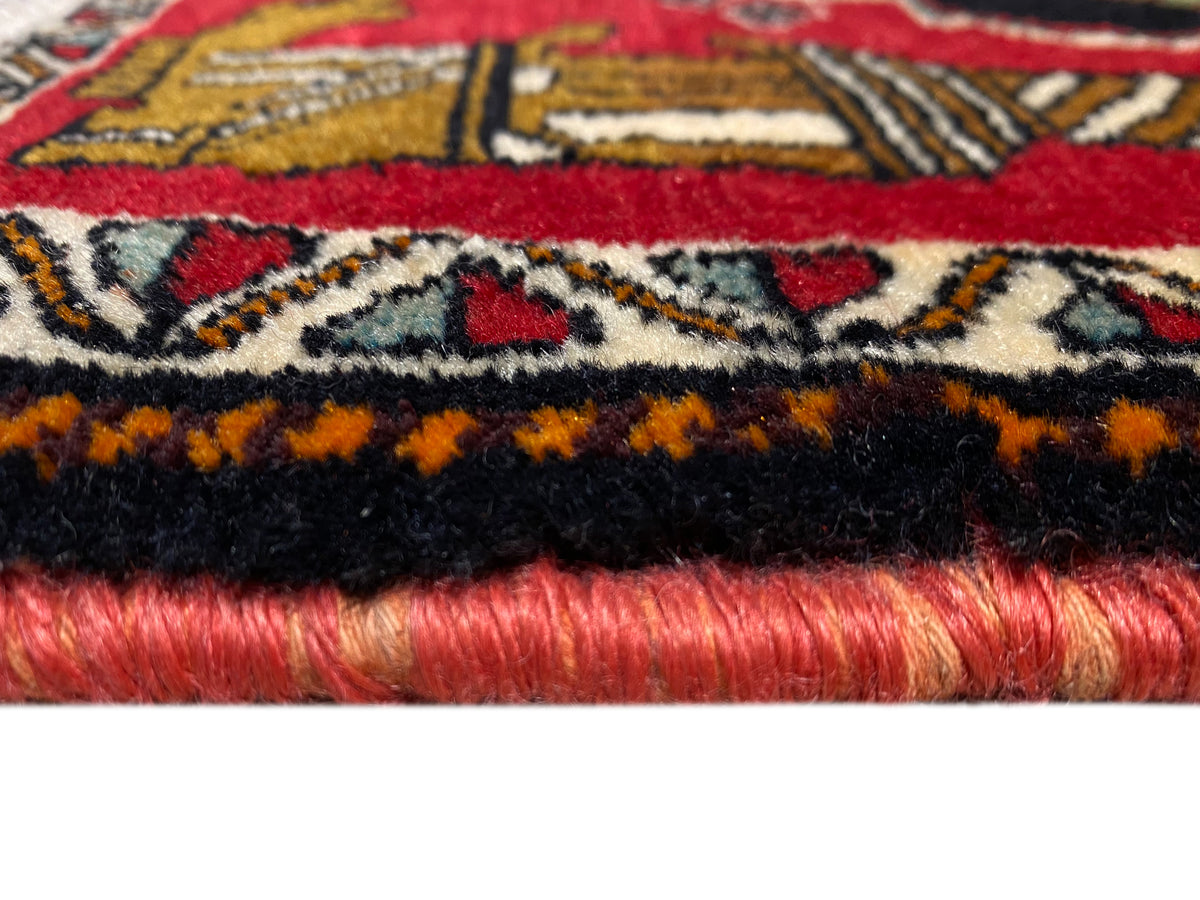 Tapete Poshti 63x55 cm: pormenor da extremidade do tapete com franjas, borda preta e pelo vermelho