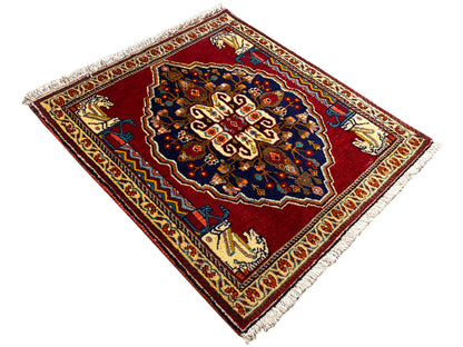 Tapete com padrão de losangos, fundo vermelho, centro azul-escuro e franjas
