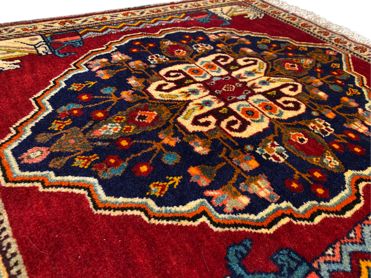 Close-up of the carpet’s centre: dark blue, red, beige and multicoloured ornamental areas