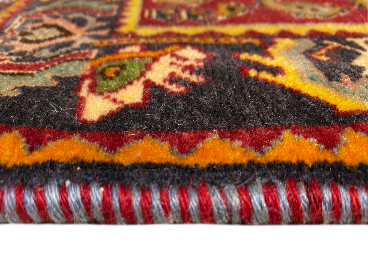 Tapete Poshti 61x61 cm em grande plano: franjas e borda multicolorida na extremidade