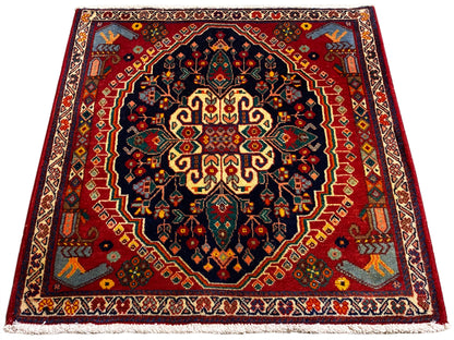 Tapete quadrado de 67x60 cm com padrão centrado em azul-escuro, vermelho e amarelo