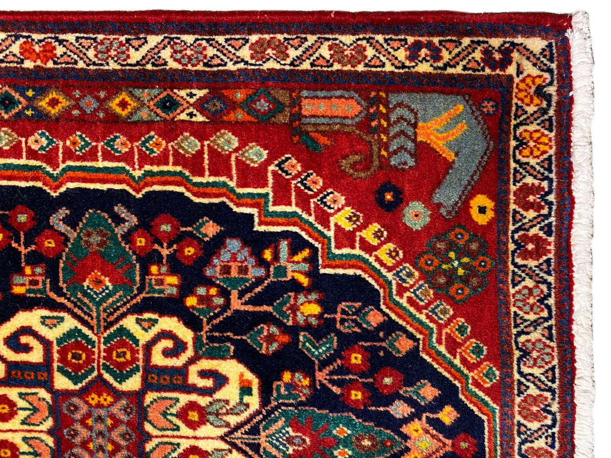 Detalhe do tapete: ornamento colorido na área azul-escura com fundo vermelho