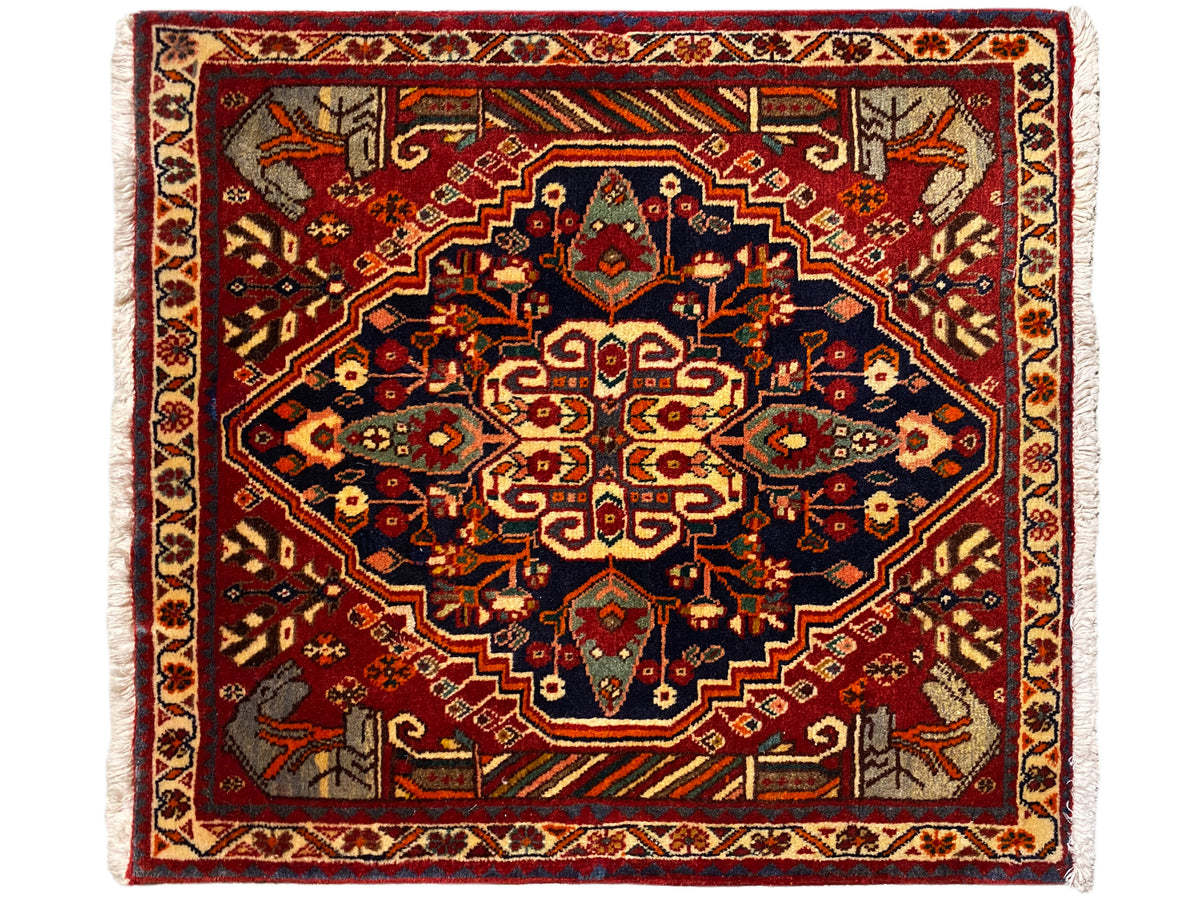 Tapete 65x59 cm com fundo vermelho, ornamentos azul-acinzentados e padrão simétrico