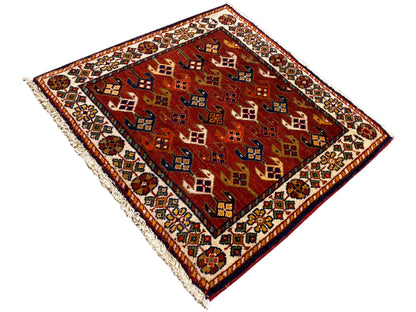 Tapete 61x61 cm com campo de padrão vermelho, bordadura multicolorida e bordas desfiadas
