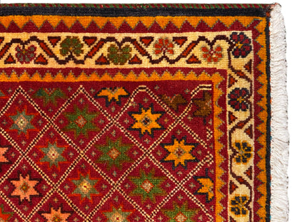 Vista de detalhe do tapete Poshti: borda ornamental colorida e padrão denso no campo interior.