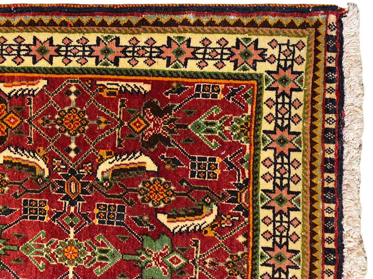 Tapete Poshti 63x61 cm Vista detalhada: campo ornamental vermelho com motivos verdes e amarelos.