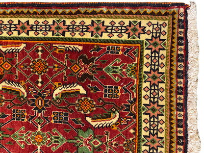 Tapete Poshti 63x61 cm Vista detalhada: campo ornamental vermelho com motivos verdes e amarelos.