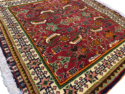 Tapete Poshti 63x61 cm, vista detalhada: padrão vermelho com motivos de animais/ornamentos e bordadura.