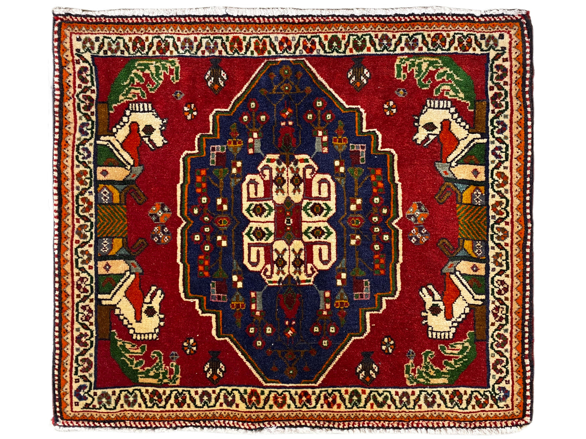 Tapete Poshti com fundo vermelho, medalhão central azul e bordadura decorativa